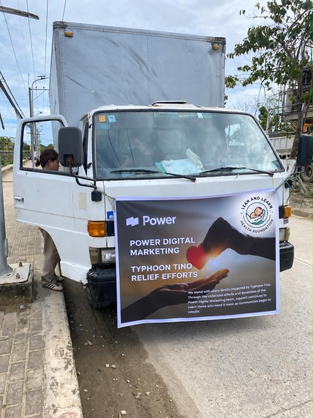 Relief delivery truck displaying Typhoon Tino relief efforts banner